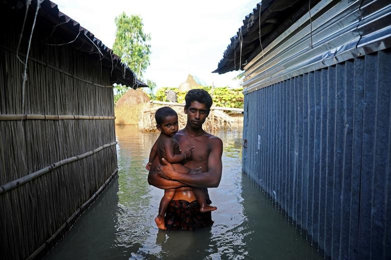 A flood-affected man stands in the water after his house got flooded in Bogura, Bangladesh. REUTERS/Mohammad Ponir Hossain  
